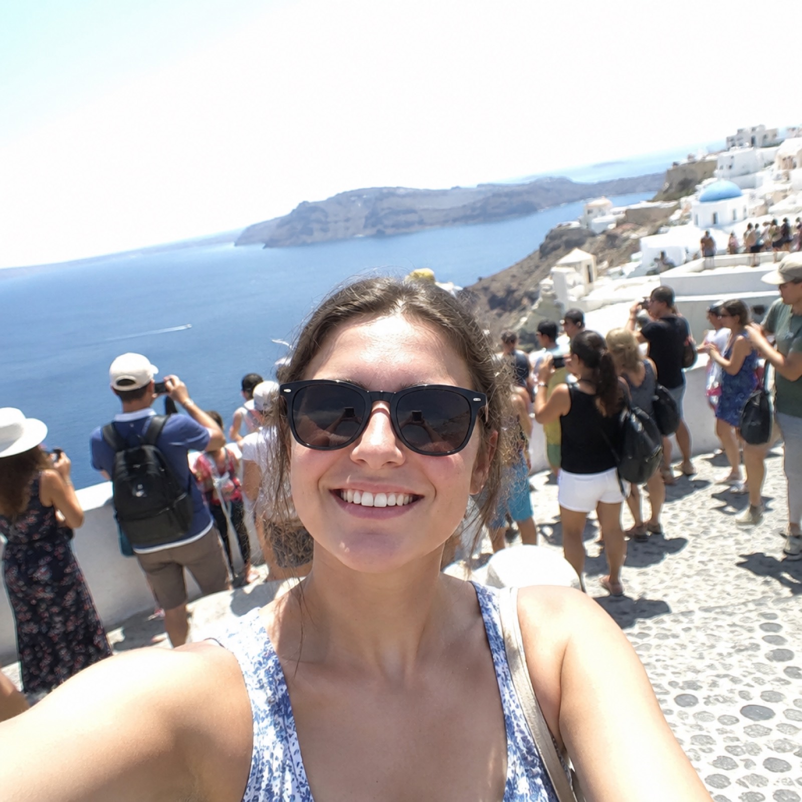 A tourist selfie at a crowded viewpoint in harsh midday light